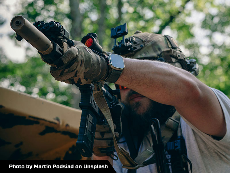 Image of a man holding a suppressed gun